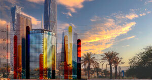 Skyline of skyscrapers with colorful facades against a sunset sky backdrop in Saudi Arabia.