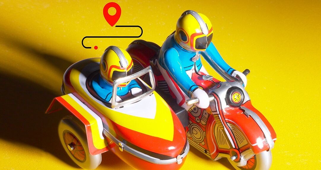 A colorful toy motorcycle with a sidecar, both painted in bright yellow, red and blue.