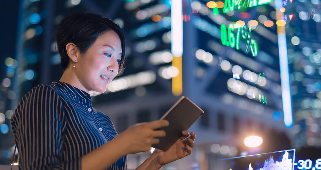 Businesswoman checks tablet to study the life insurance industry in China.